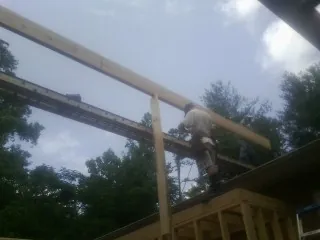 Carpenter setting a ridge beam over a new addition frame — Ice Dam Removal by Roofing Brothers in Port Barre