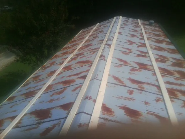 Rusted metal roof panels with new wood purlins before replacement — Storm Damage Roof Repair in Port Barre by Roofing Brothers