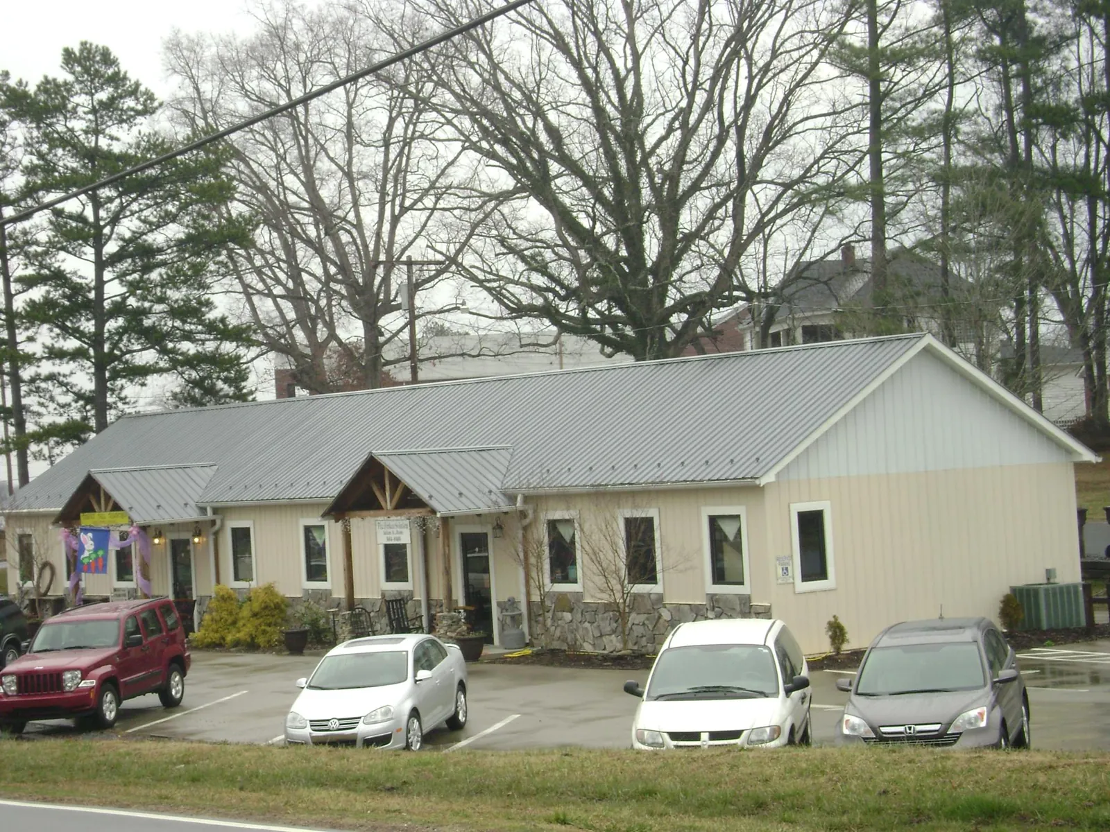 Gray metal roof with timber entry brackets on a small commercial building in Port Barre
