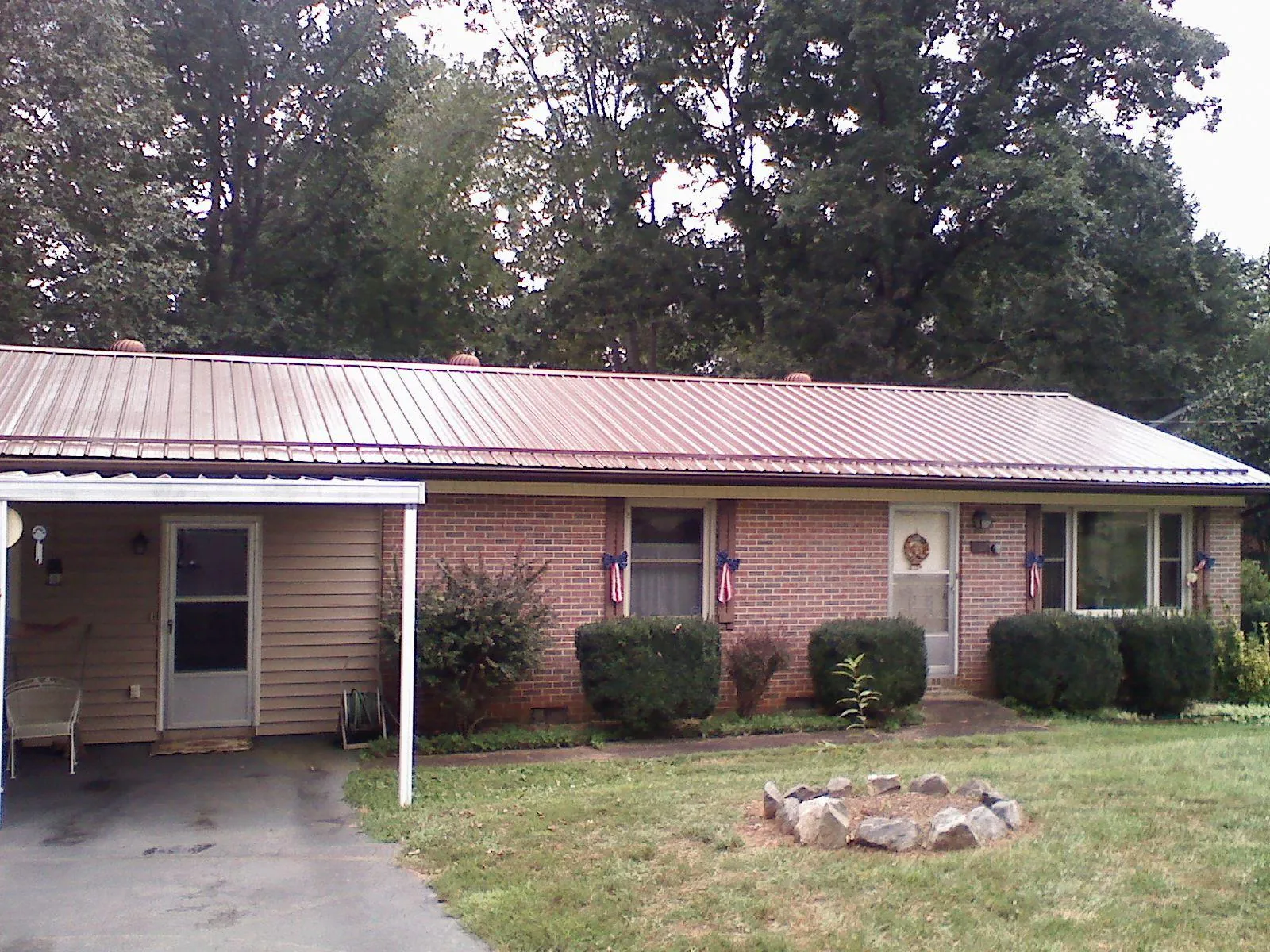 Bronze metal roof and carport on a brick ranch home — Roof Repair work by our crew in Port Barre