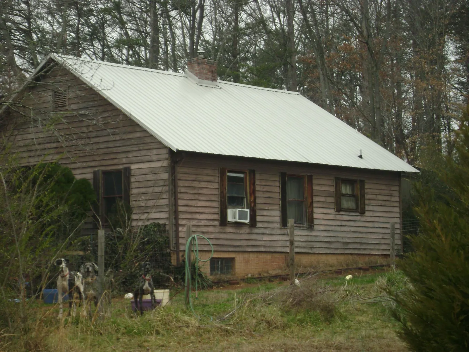 White metal roof on an old wood sided farmhouse, from a Metal Roof Installation job in Port Barre